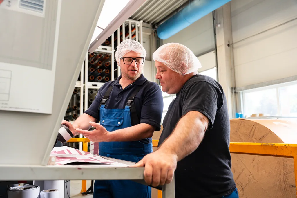 Zwei Flexopack-Mitarbeiter im Gespräch an der Druckmaschine